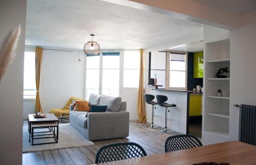 un salon avec un canapé et une table dans l'établissement Next to Disney Appart' Le Rêve Bleu, à Torcy