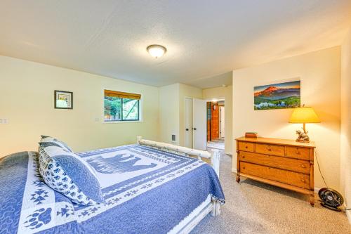 a bedroom with a bed and a dresser with a lamp at 5 Mi to Mt Rainier Natl Park Cozy Cabin with Deck! in Ashford