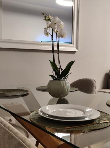 a table with a vase with white flowers in it at Cangas con encanto in Cangas de Morrazo