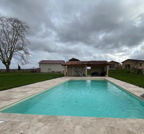 a swimming pool in front of a house at Gîte les Vabres - Ancienne ferme rénovée piscine pétanque in Coufouleux