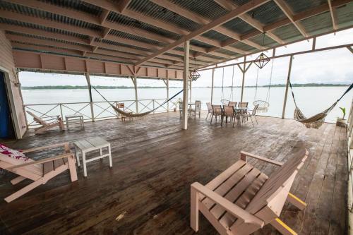 a room with chairs and tables and a hammock at La Caribena Beach House- Bocas del Toro, Isla Colón, Panamá in Big Creek