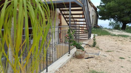 a house with a staircase next to a building at Casolare La Torre in Scopello