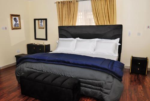 a bedroom with a large bed and a couch at Crosswater Lodge Abuja - Short Let & Luxury Apartment in Kubwa