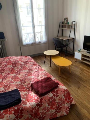 - une chambre avec un lit et deux tables dans l'établissement Logement proche gare , tram direct circuit, au Mans