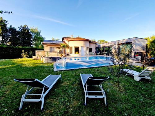 une cour avec deux chaises et une piscine dans l'établissement Villa familiale de Collonges, à Collonges-au-Mont-dʼOr