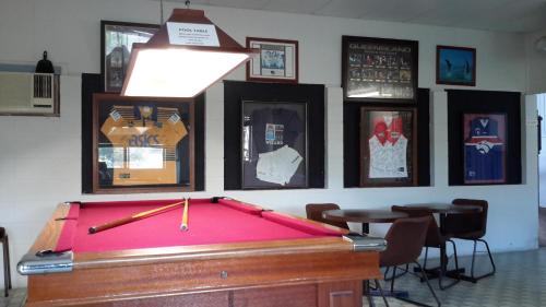 a pool table in a room with pictures on the wall at Herbert Valley Motel in Ingham