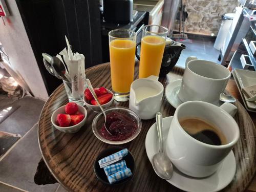 een houten tafel met een kopje koffie en drankjes bij Le Tempo in Entrecasteaux