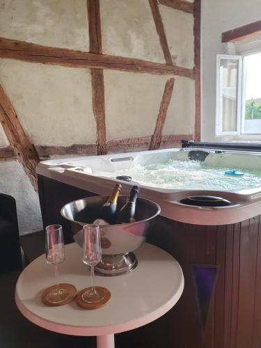 a jacuzzi tub with two glasses on a table at Domaine d'Alémanie in Ebersmunster