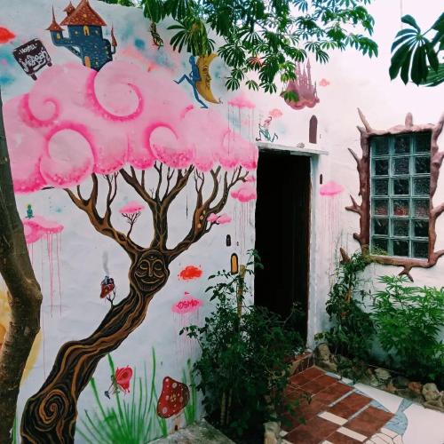 a mural of a pink tree on the side of a building at Hostel Morgan in Piriápolis