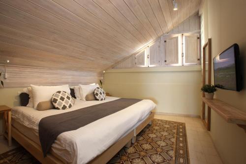 a bedroom with a large bed with a wooden ceiling at Dar Alma in Soûr