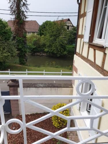a white railing on a balcony with a view of a river at Domaine d'Alémanie in Ebersmunster