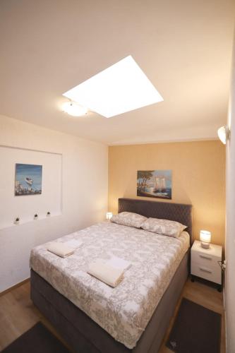 a bedroom with a large bed with a large ceiling at Apartmani Vesna in Vir