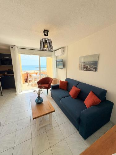 a living room with a blue couch and a table at Panoramic Sea View Chic & Cozy home holiday in Sète