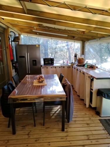 une cuisine avec une table en bois et un comptoir dans l'établissement Mobil home camping 5 étoiles, à Puget-sur Argens