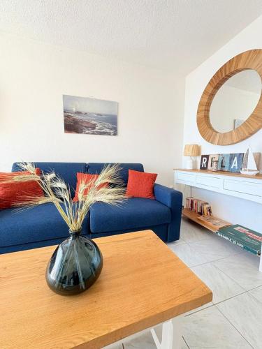 a living room with a blue couch and a table at Panoramic Sea View Chic & Cozy home holiday in Sète
