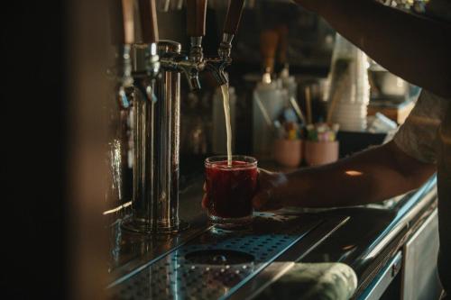 a person pouring a drink into a glass at El Caminante Bar & Bungalows in Dana Point