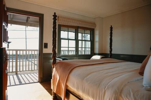 a bedroom with a large bed and a balcony at El Caminante Bar & Bungalows in Dana Point