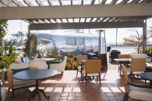 an outdoor patio with tables and chairs and an rv at El Caminante Bar & Bungalows in Dana Point