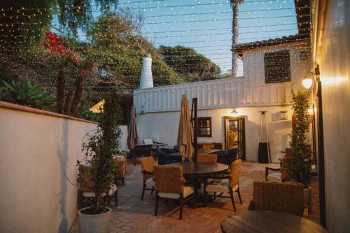a patio with a table and chairs and a building at El Caminante Bar & Bungalows in Dana Point
