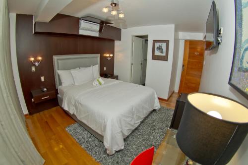 a bedroom with a bed and a flat screen tv at Arvo Hotel Boutique in Trujillo