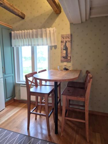 a wooden table and chairs in a room with a window at NINA - Cosy 3 bedroom house in calm area with garden in Närpiö