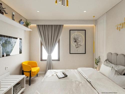 a bedroom with a large bed and a yellow chair at Best Western Plus Hotel Saint-Roch Orleans in Orléans