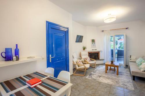 a living room with a blue door and a couch at Hillside Hideaway in Paliouri