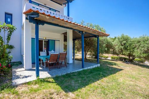 a patio with chairs and a table on a house at Hillside Hideaway in Paliouri