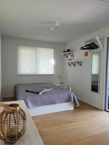 a bedroom with a bed and a window and a table at Vasarnieki 24 in Ziemupe