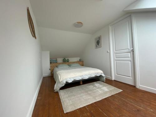 une chambre avec un lit et un parquet dans l'établissement Duplex Belle Rade, à Dunkerque