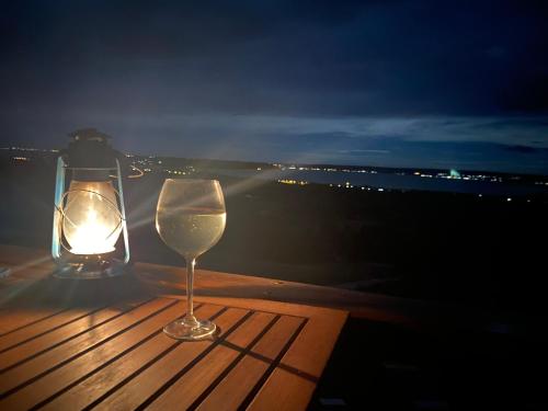 a wine glass sitting on a table with a candle at Kisleshegy Vászoly Vendégház in Dörgicse