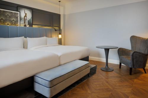 a hotel room with a bed and a chair at The Queens Hotel in Leeds