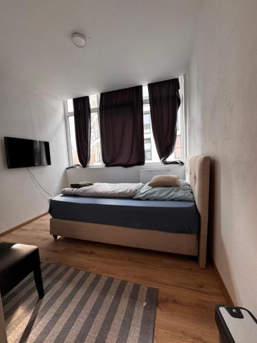 a bedroom with a bed and a window at A&B Ferienwohnungen in Rosenheim