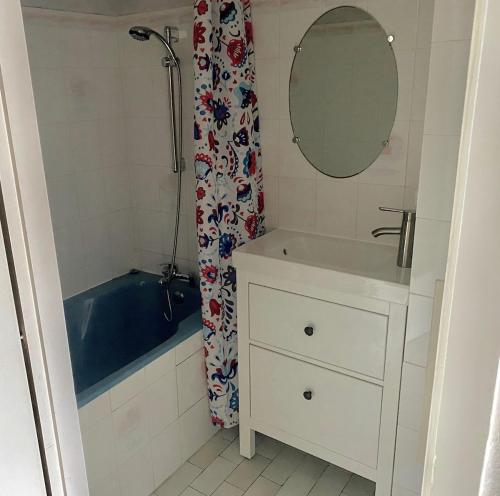 une salle de bain avec une baignoire, un lavabo et un miroir dans l'établissement Appart à 2 pas de la grande plage, à Les Sables-dʼOlonne