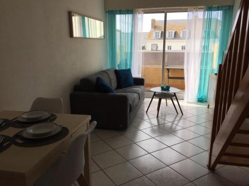 un salon avec un canapé et une table dans l'établissement Appart à 2 pas de la grande plage, à Les Sables-dʼOlonne