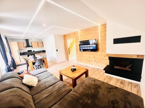 un soggiorno con divano e camino di Duplex cosy proche Gérardmer a Le Tholy