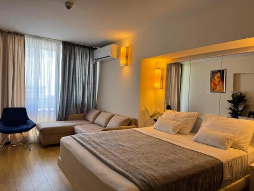 a hotel room with a large bed and a couch at Batumi Aparthotel In Orbi City 2025 in Batumi