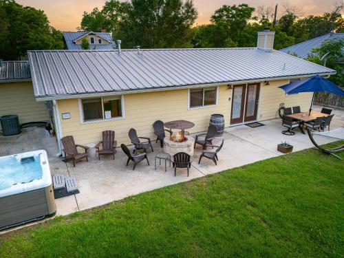 eine Terrasse mit Stühlen, einem Tisch und einem Haus in der Unterkunft Porch & Pour - Hot Tub & Fire Pit in Fredericksburg