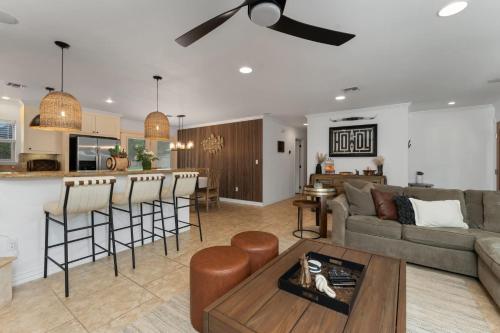 ein Wohnzimmer und eine Küche mit Sofa und Tisch in der Unterkunft Porch & Pour - Hot Tub & Fire Pit in Fredericksburg