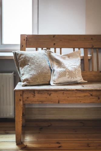 two pillows are sitting on a wooden bench at Classical large apartment on Alberta street, FREE locked PARKING in Riga