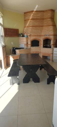 a kitchen with a table and a brick wall at Alto padrão !Forno Pizza! Hidro !Vista linda! in Poços de Caldas