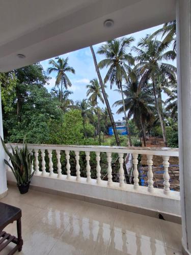 a balcony with a view of palm trees at White House Beach Apartments in Mandrem