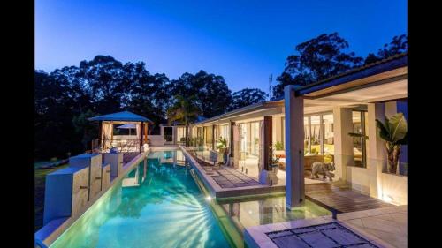 a house with a swimming pool next to a house at Alaya Verde Bed & Breakfast in Ringtail Creek