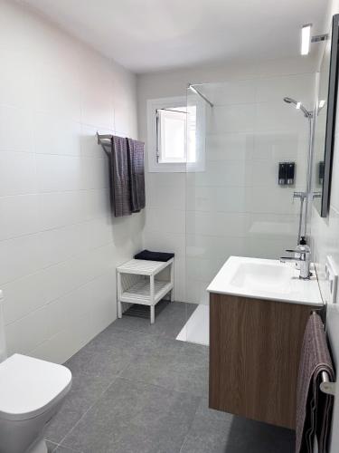 a white bathroom with a toilet and a sink at Apartamento Careme in Tavernes de Valldigna
