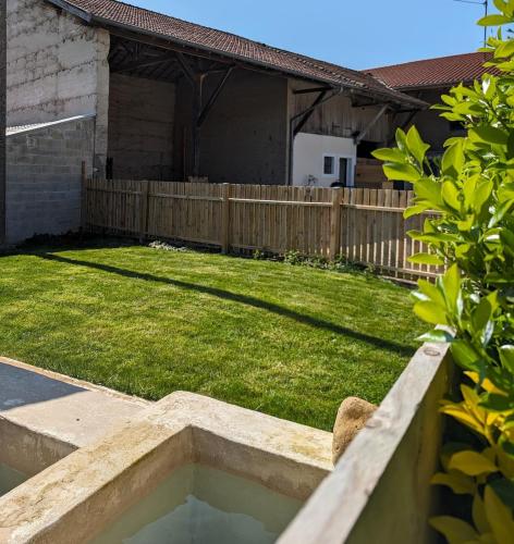 a backyard with a fence and a yard withgrass at La Maison de Pérouges in Pérouges