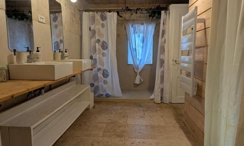 a bathroom with two sinks and a window at La Maison de Pérouges in Pérouges