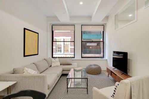 a living room with a couch and a table at The Ledger Residences by Sosuite - Old City in Philadelphia