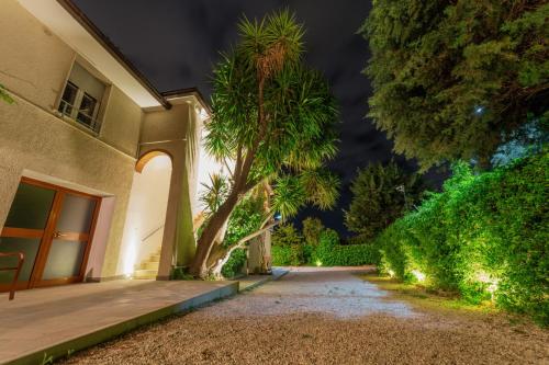 a house with a palm tree next to a driveway at Villa Yucca - B&B and Glamping in Torano Nuovo