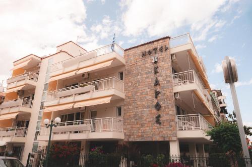a building with a clock on the side of it at Ikaros Apartments in Paralia Katerinis