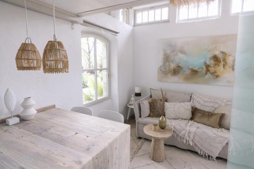un salon avec une table en bois et un canapé dans l'établissement LA GARE DE L'ART - Gästehaus im ehemaligen Bahnhof, à Rouairoux